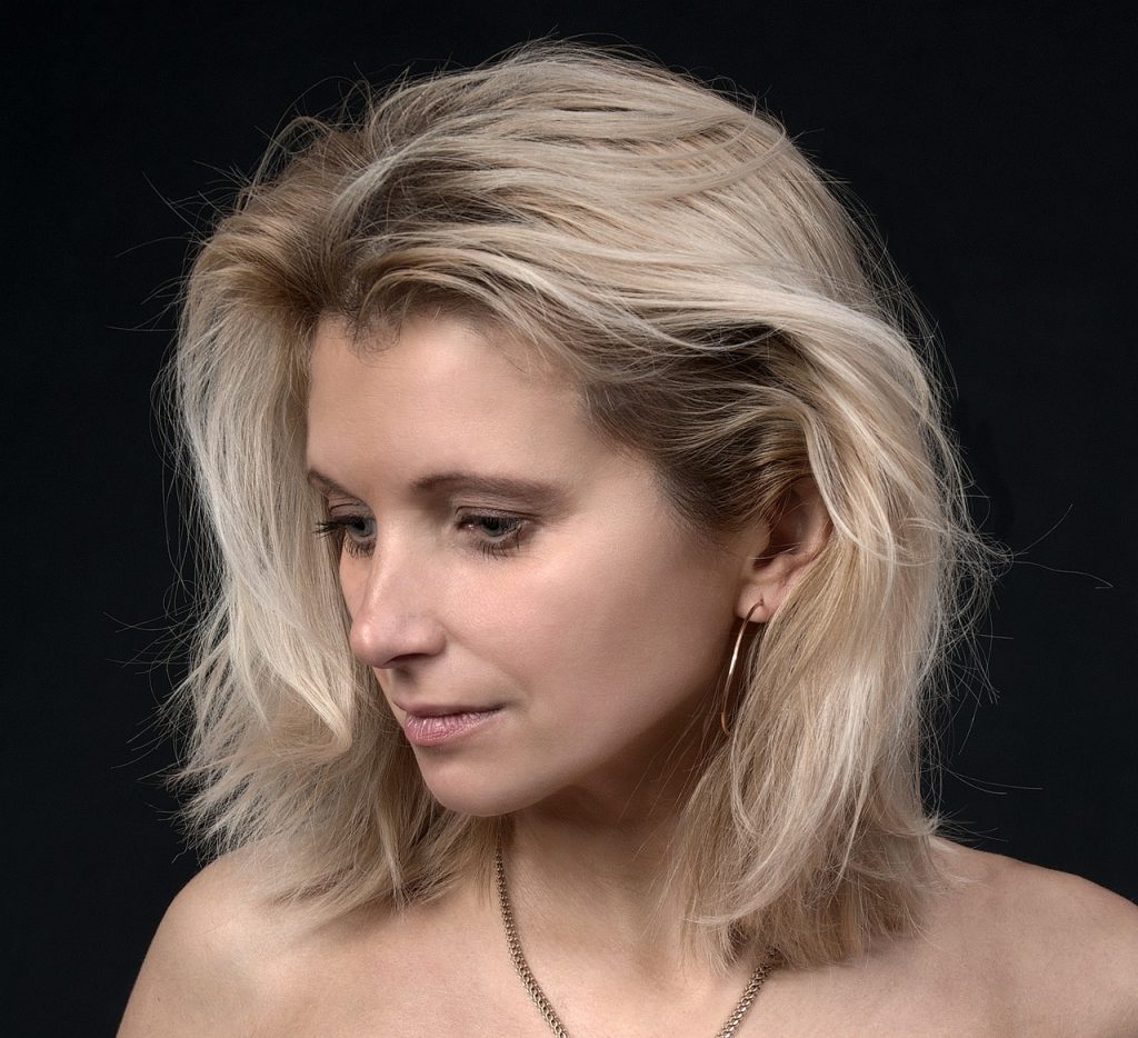 Kobieta z jasnymi, blond włosami o zdrowym, lśniącym wyglądzie
